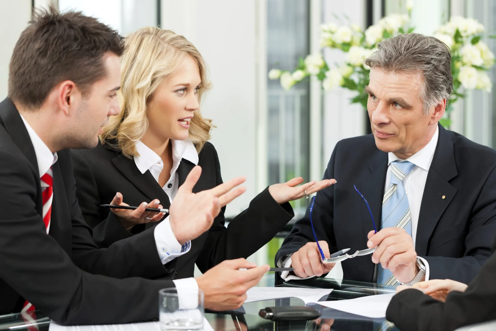 Business lunch. Business people sitting at table at restaurant looking at each other discussing